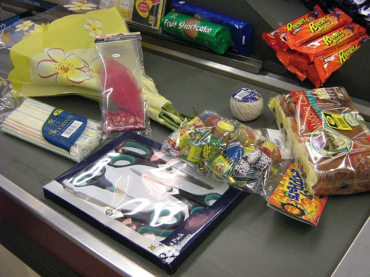 Caixa de supermercado em operação com compras na esteira