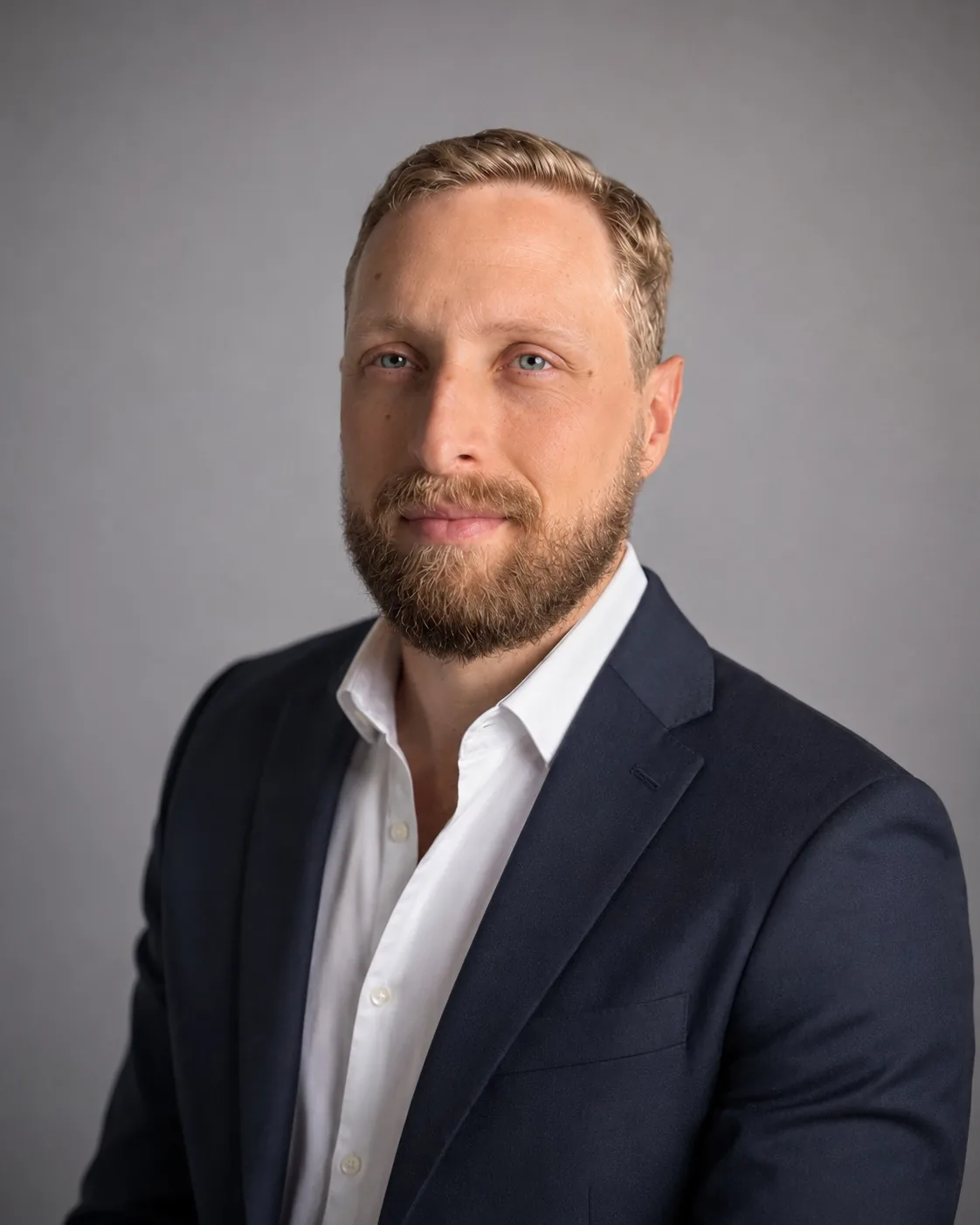 Osmar Gusso Neto, consultor financeiro empresarial, em retrato profissional de blazer azul-marinho