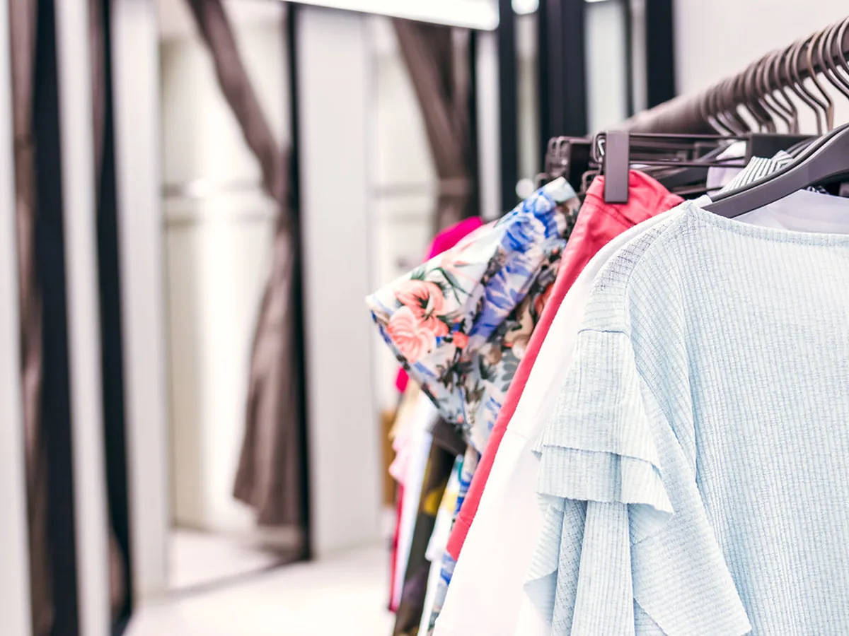 Araras de roupas organizadas em loja de moda